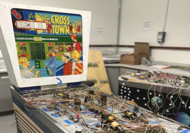 Pinball machine with playfield electronics exposed.